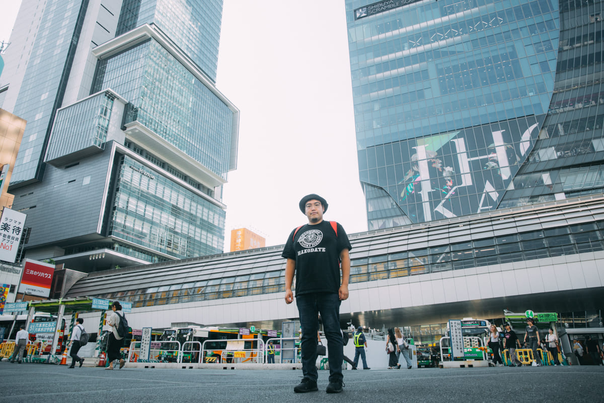 渋谷のビル街に立つ茸本さん