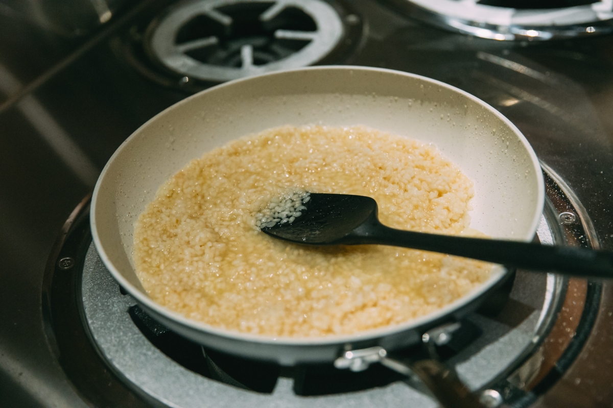 炒った米を少量の湯で茹でている写真